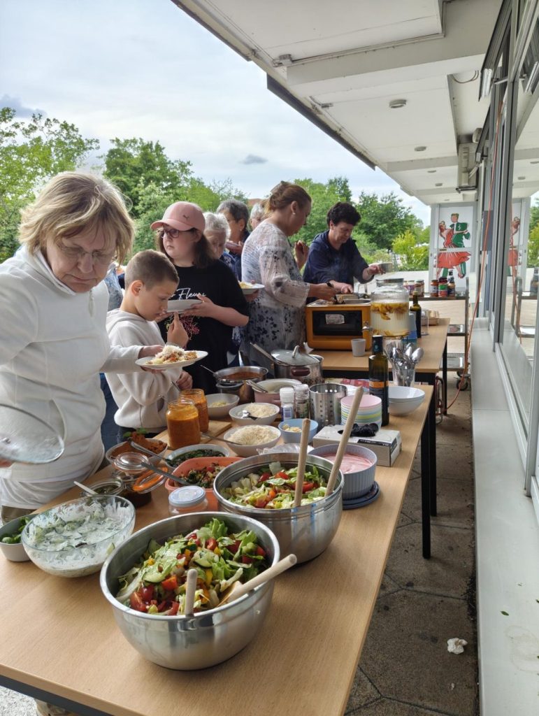 Menschen bedienen sich am Buffet